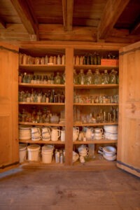 Blick in den Einbauschrank in der Seifenkammer mit diversen Flaschen und Behältnissen