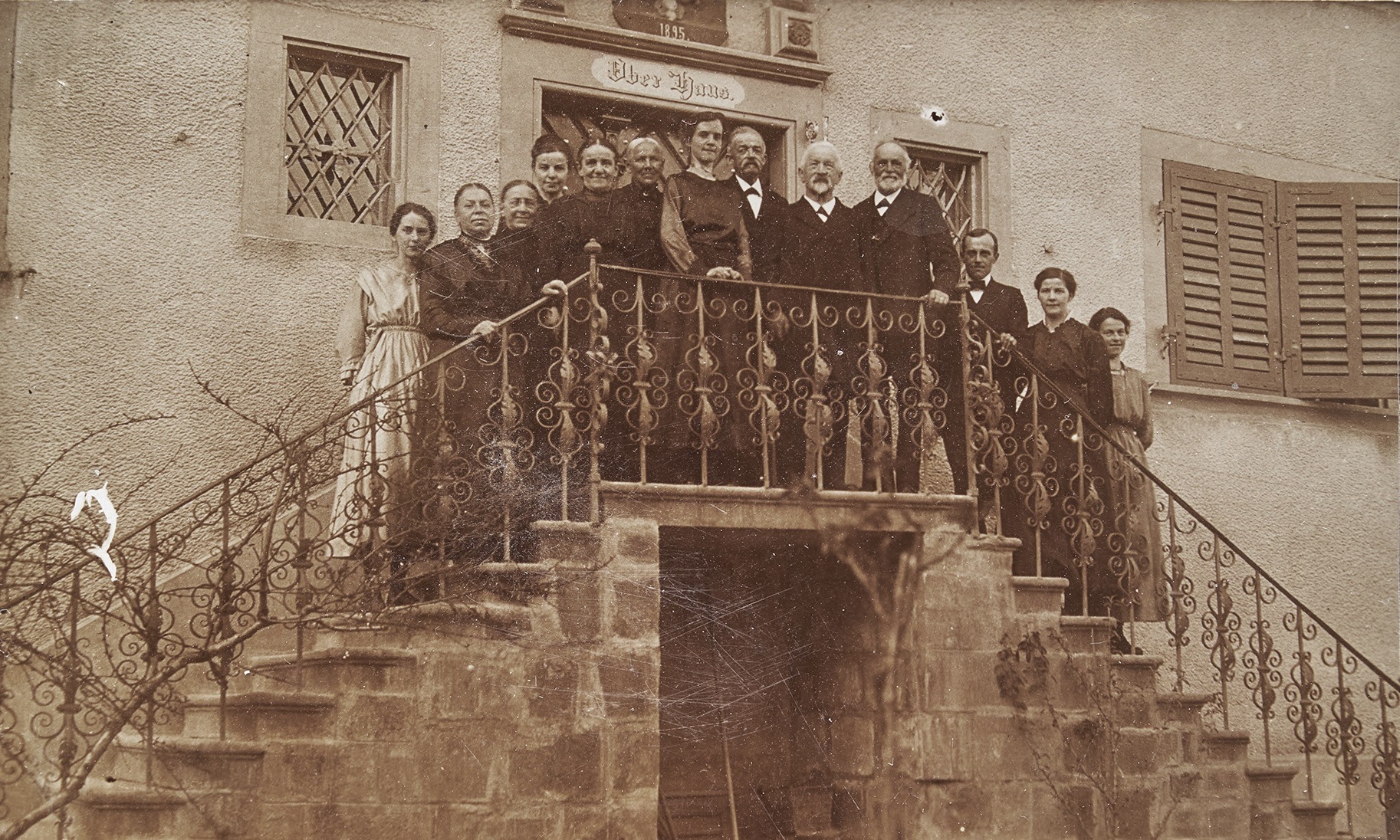 Schwarz-Weiss-Fotografie der Bewohnerinnen und Bewohner des Oberhauses, die auf der nördlichen Freitreppe vor dem Haus posieren