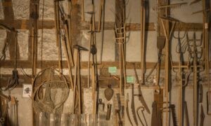 landwirtschaftliches Gerät ist an einer Wand aufgehängt